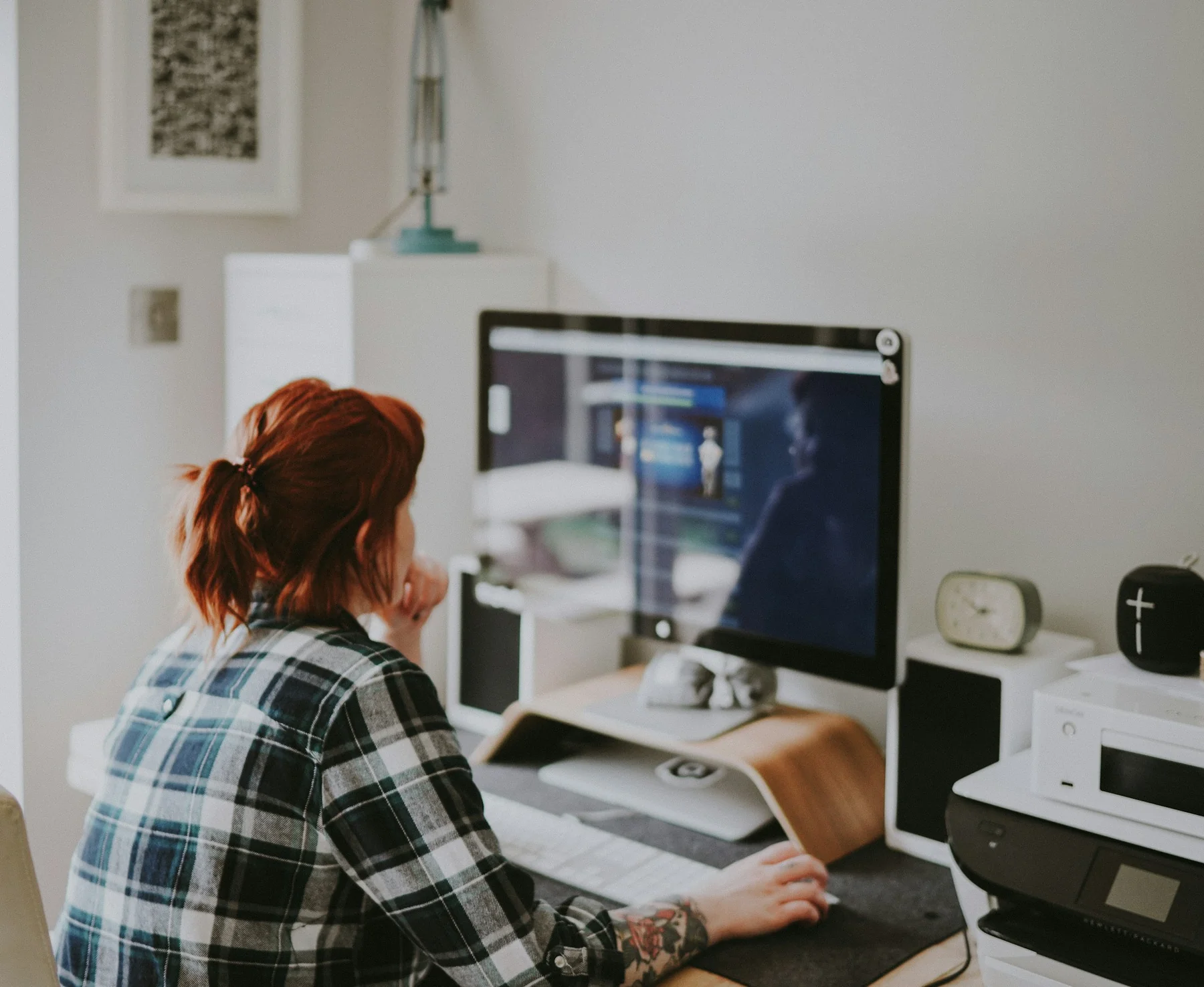A person working at a desktop in a small workspace