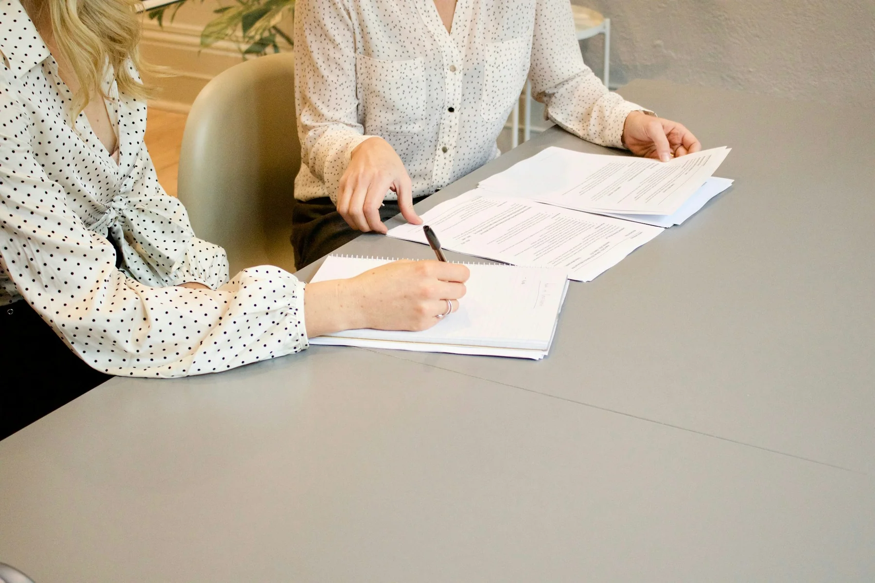 Two people reviewing and making notes on paperwork